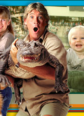 The image is a vibrant, multi-layered collage. At the center, a man in a tan shirt is the main focus. He's holding a baby alligator in his hands, which adds an element of surprise and cute appeal. The background is divided into two sections. On the left, there's a picture of two females, possibly a mother and daughter, sharing a joyful moment. On the right, a smiling baby is seen, adding to the overall cheerful atmosphere of the image.