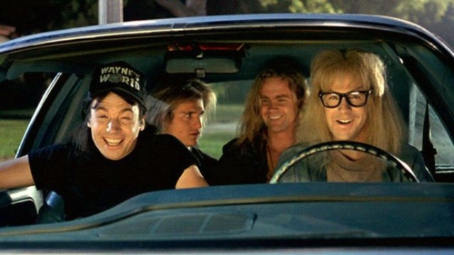 How about a 'period' classics pictures thread - Page 210 - Classic Cars and Yesterday's Heroes - PistonHeads - In the image, we see an ensemble of four characters from the iconic film "Wayne's World". They are seated inside a classic blue car, and each character is clearly visible and more or less seated. The characters are well-known for their roles in the film and their larger-than-life personalities. Stylistically, the image appears to be a still from the film itself, capturing a moment of joy or camaraderie among the characters.