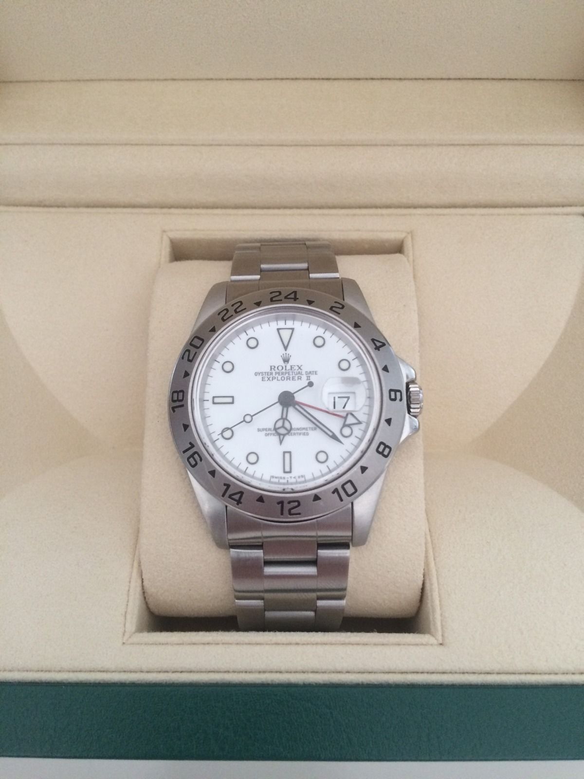 Entry Level Rolex - Page 1 - Watches - PistonHeads - This image depicts a wristwatch presented in an open jewelry box, placed against a neutral-toned background. The watch has a round face with white dials, black hands, and markers and shows indications for minutes and hours. The bezel is silver with minimal embellishment, and the band appears to be of the same metallic material. The watch's mechanism is visible on the case back, indicating that it could be a classic or vintage timepiece. The overall style of the watch suggests functionality and aesthetic appeal.