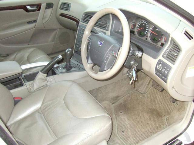 A car is parked next to a parking meter - Pistonheads - The image shows the interior of a car, focusing on the driver's seat. The seat is large, filled with white upholstery, and there's no one sitting in it. Directly in front of us, we see the steering wheel and gauge cluster, which portrays different gauges. On the left side of the car, there are windows and the door is closed. The car appears to be well-maintained, suggesting it is a used vehicle. The overall lighting in the image is bright, enhancing the visibility of the car's interior.