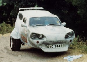 Endulge Seconds Pistonheads - The image depicts a white car parked by what appears to be a dirt path that's adjacent to trees with a dense canopy. The car has a unique design, possibly a modified small vehicle, with its odd headlights and prominent front grille. Its license plate number is BVC 334. Surrounding the area, there are signs of weathering, suggesting the vehicles have been there for some time. Additionally, lies scattered on the ground hint at some outdoor human activity.