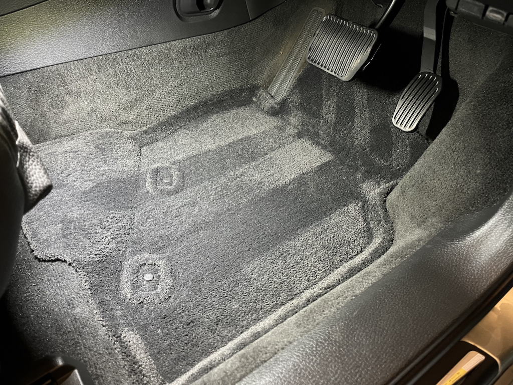 2005 Volvo V70 2.5T SE - Page 5 - Readers' Cars - PistonHeads UK - The image presents an interior view of the trunk compartment of a vehicle. The trunk lining has been removed, revealing bare metal surfaces. It appears to be a professional cleaning setup with various tools and materials neatly organized around the trunk space. There's a noticeable dusty or soiled appearance on the floor mats and other parts of the trunk area. A carpet cleaner is visible among the tools, suggesting that deep cleaning is taking place. The image conveys a sense of thorough maintenance being performed on the vehicle.