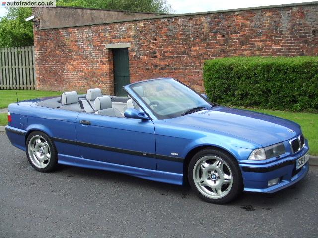 So what car have you been obsessing about today?? (Vol 2) - Page 421 - General Gassing - PistonHeads - The image shows a blue convertible car parked beside a red brick wall. The car appears to be in good condition, with the top down, revealing its two-seater design. The car's name is BMW, suggesting it is a German luxury vehicle. The license plate on the front of the car is partially visible but not fully legible, leaving its registration details unknown. The car is photographed during daylight hours to show the vehicle's shiny bodywork and painted brick wall as its background.