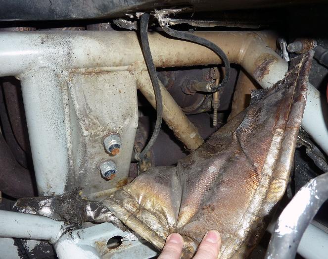 Pistonheads - The image shows an under-the-hood perspective of an engine compartment. The focus is on a section of the car's engine bay, featuring a dirty and rusted portion of a wire harness with parts of the metal exposed, suggesting damage or age. There are also mosaic tiles on the wall at night above an orange since at night; mosaic tiles can create an intricate and mesmerizing visual effect.