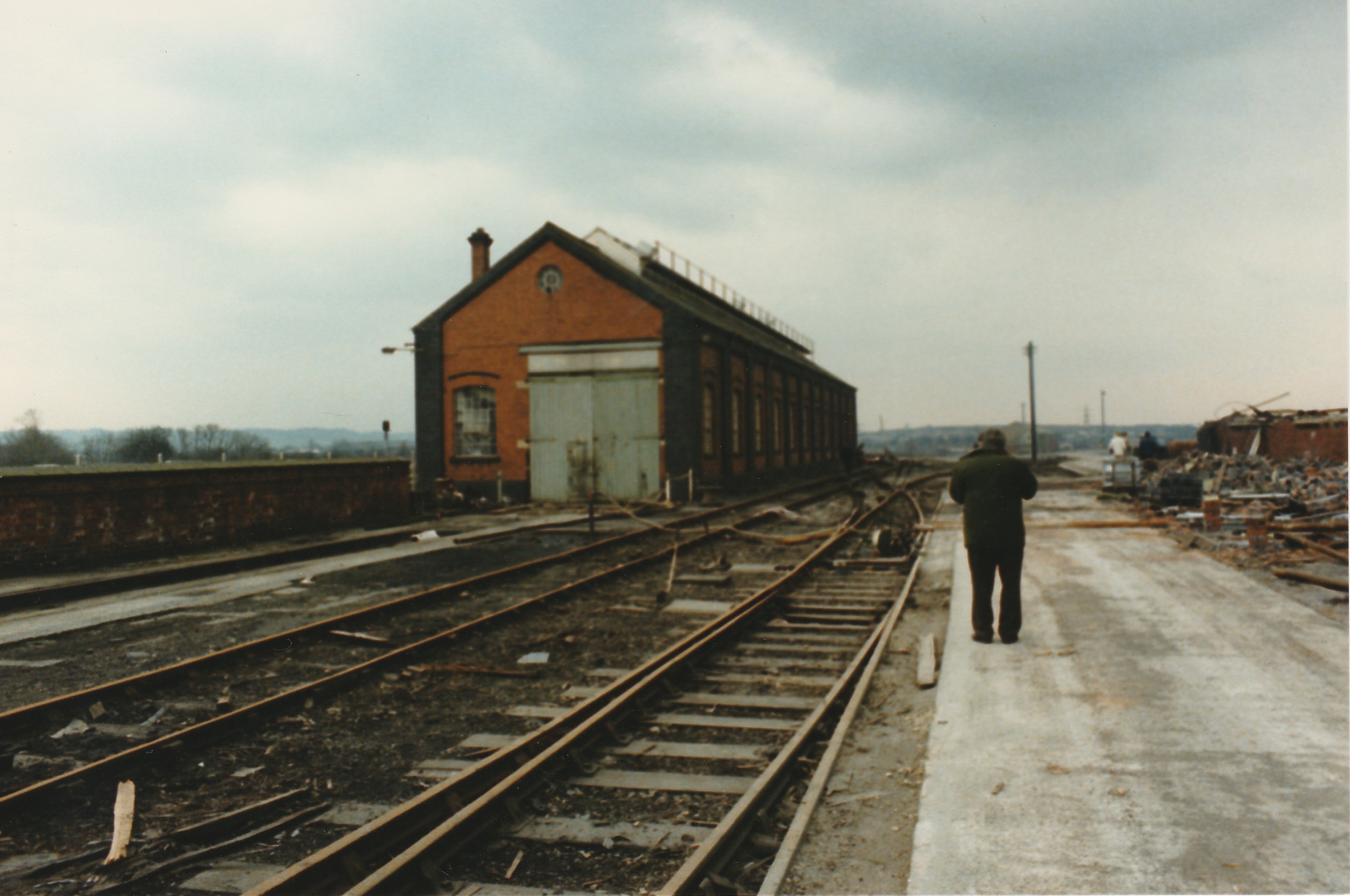 Pistonheads - The image captures a scene of an abandoned train station. A person is standing on the platform, adding a sense of scale to the otherwise empty space. The station features multiple train tracks extending into the distance, suggesting it was once a busy hub of transportation. The surrounding area appears somewhat dilapidated, with buildings and structures showing signs of disuse. Despite the apparent desolation, the image conveys a certain timeless quality.