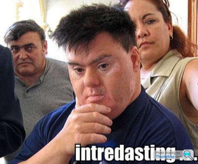 The Internet Meme Thread - This image features a young man in the center, prominently displayed, with a puzzled or pondering expression. Two other individuals, one standing and one seated, are present, seemingly observing the man or the camera. The person standing is to the right of the man, while the seated person is to his left. The background is indistinct but seems to be an indoor setting. In the bottom right corner, there's a watermark or logo reading "introdsting" followed by a web address.