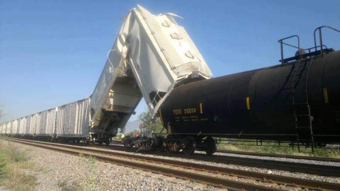 The camera can capture some fantastic moments V - Page 73 - Photography & Video - PistonHeads UK - The image shows a train on the tracks, with a cargo car attached to it. There is a truck-like vehicle with a large crane arm extended over the train, appearing to be in the process of loading or unloading cargo. In front of the cargo car is another train car that has been knocked onto its side by some unknown force, causing it to rest on the tracks. The surrounding environment looks like a rural area with trees and grass visible. The sky is clear, suggesting good weather conditions. There are no people visible in the image.