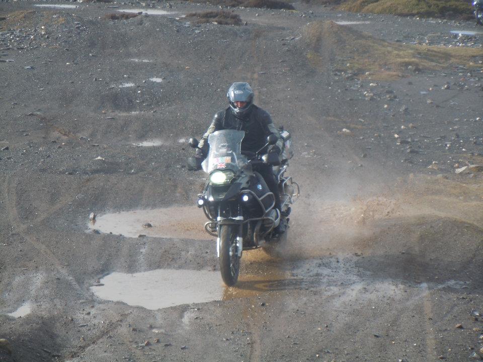 A man riding a motorcycle on a dirt road - Pistonheads