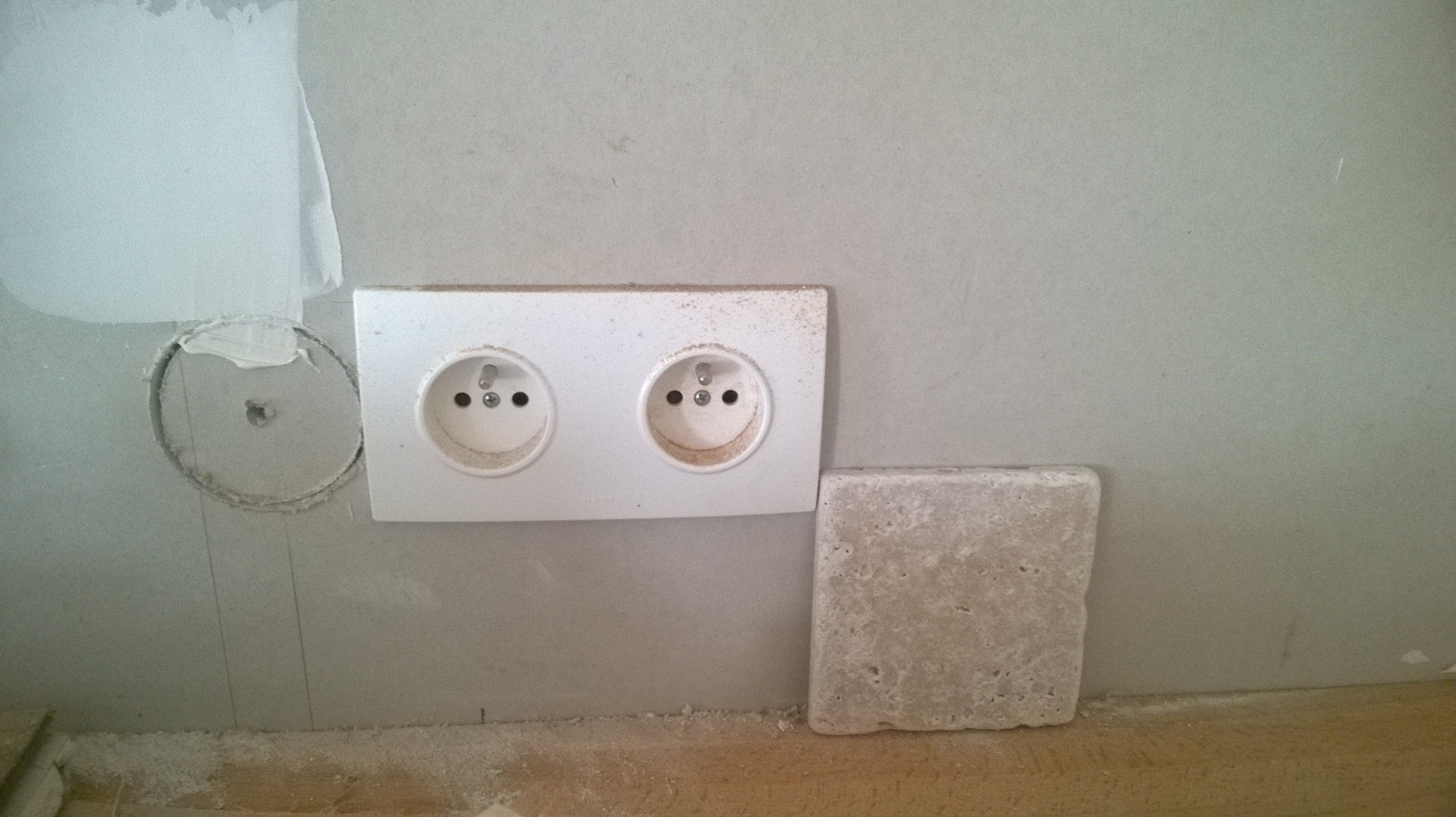 Our French farmhouse build thread. - Page 18 - Homes, Gardens and DIY - PistonHeads - This image shows the back of an electrical outlet embedded in a thick white wall. To the left of the outlet, a large hole in the wall is visible, with an exposed wire visible from inside. On the right, leaning against the wall, there is a small white block. Another hole, presumably intended for another outlet, is to the right of the first block.