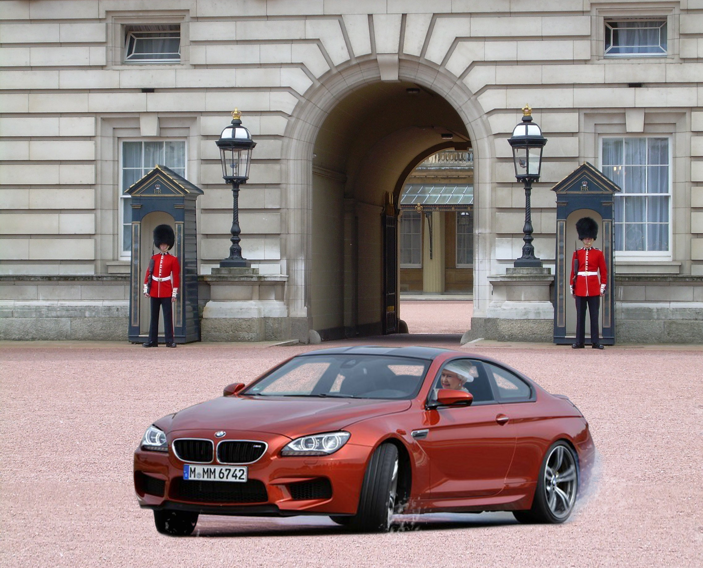 RE: Pic of the Week: An M6 going sideways - Page 1 - General Gassing - PistonHeads - The image is a composite with a real-world photograph and digital elements. At the center, a vintage red BMW sports car, specifically a limited edition MM 672, is captured. It's positioned sideways across a dry, red-painted area, adjusting the rear end's angle, making it appear as if it just performed a burnout. Around the vehicle, two? soldiers stand at attention, reminiscent of the Queen's Guard at Buckingham Palace. The background reveals an ornate, historical building and perfectly aligns with the perspective of the cars' motion blur.