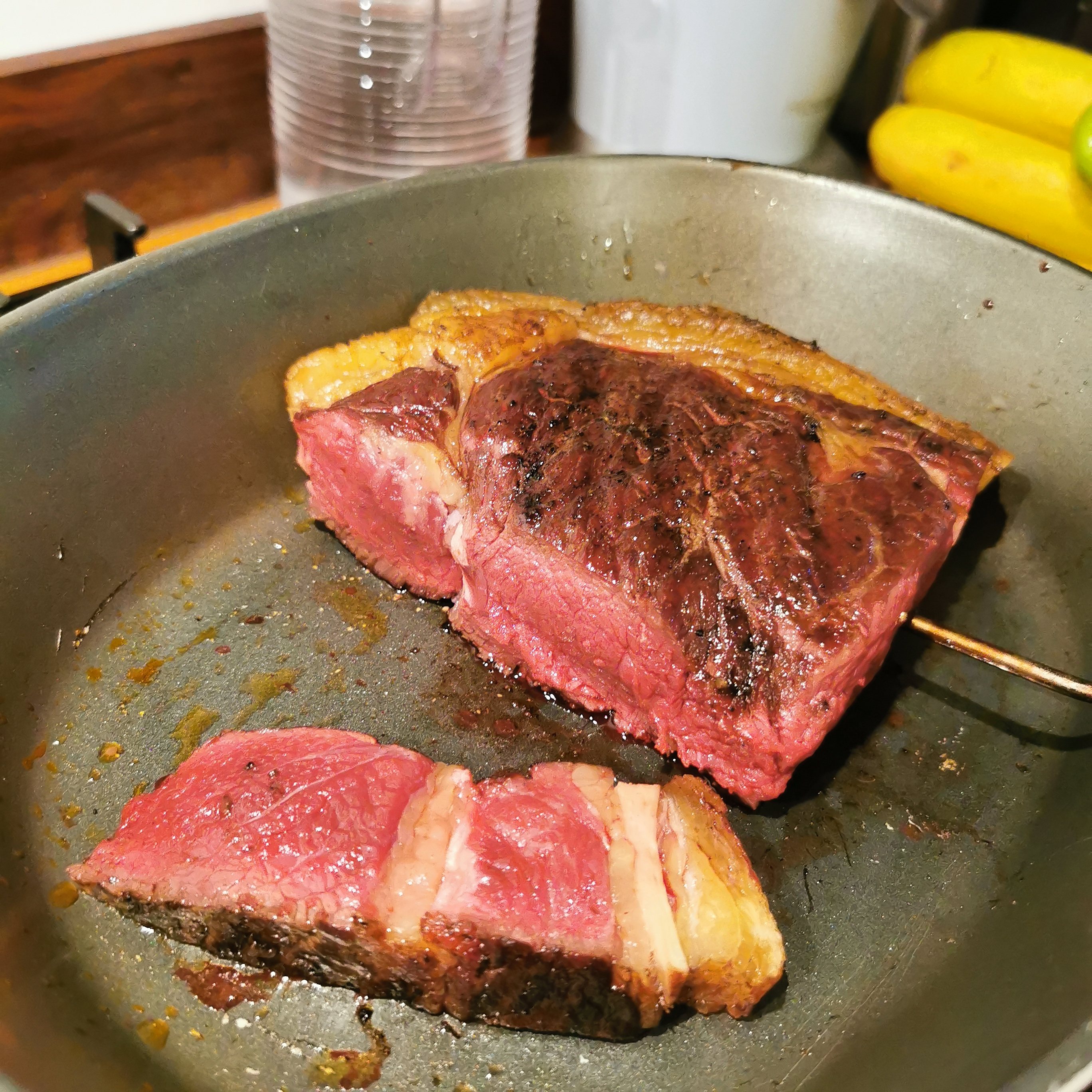 THE  STEAK THREAD, served a la Man. - Page 112 - Food, Drink & Restaurants - PistonHeads UK - The image displays a close-up of a wooden cutting board with a piece of cooked meat and a slice of meat. To the left, there is a whole roast, which appears to be pinkish in color, suggesting it might be rare or medium-rare. Adjacent to it on the right, there are two slices of meat that look like they have been seared or grilled. The background is blurred but hints at a kitchen environment with a wooden table visible. There are no texts present in the image.