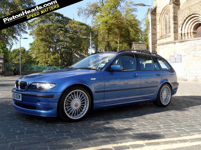 Pistonheads - This image features a bright blue BMW car parked on a cobblestone street. The car's design includes a sleek body with aerodynamic lines, a prominent grille bearing the BMW logo, and large alloy wheels. The car's sleek design contrasts with the rustic charm of the cobblestone street, which has a traditional European feel. In the background, there are trees, a building with a pointed roof, and a clear sky. Across the bottom of the image, there is text that says "PistonHeads.com Speed Matters," indicating the source or sponsor of the image.