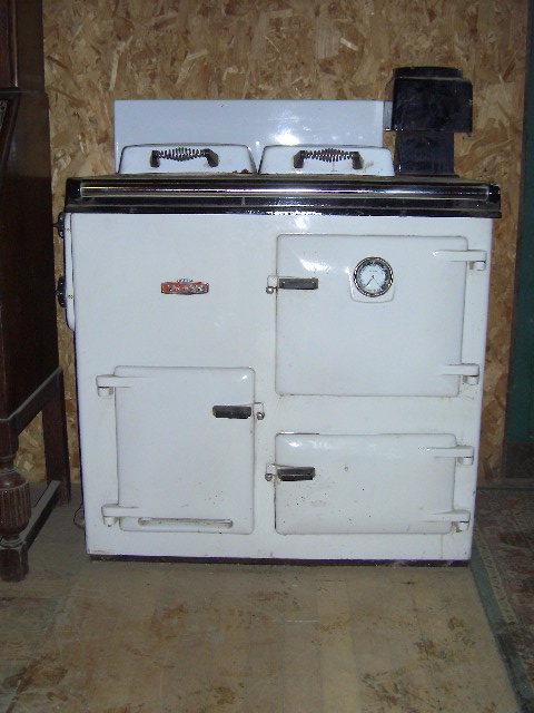 Trailer needed..... - Page 1 - South Wales - PistonHeads - In the image, a vintage white oven with two burners on top is situated on the right. It appears to be an older model given the visible brand "Frigidaire." The oven's overall look is simple and utilitarian. The oven is wall-mounted and is likely to be found in a kitchen setting. It is framed by a wooden floor at its base. There is no significant activity or movement in the scene.