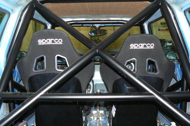 Pistonheads - The image showcases the interior of an automobile, focusing on the driver's side. Dominating the scene are two black bucket seats labeled "SPARCO," which are renowned for their comfort and support. The seats are set side by side, with the driver's seat positioned closer to the steering wheel, a typical configuration for driving. The image is taken from a lower perspective, giving viewers a sense of the cosy and inviting setting that awaits the driver. In the background, the upholstery transition Ms to Mr, suggesting the car is a coupe styled vehicle.