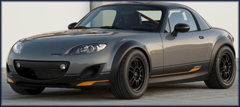 Do you think a Mazda MX-5 NC is girly? - Page 1 - Mazda MX5/Eunos/Miata - PistonHeads - The image showcases a sleek, sparkling, dark-colored sports car that is parked outdoors, possibly on a concrete surface or a parking lot. The car's design features a black soft top and a sunroof, with the top portion of the car being black and matte. There is a yellow trim line that runs along the bottom of the car and includes the headlamps, which are tilted slightly upward. The car's tires are black and appear to be well-maintained, suggesting the vehicle is carefully taken care of. The overall impression is of a luxurious and stylish automobile.