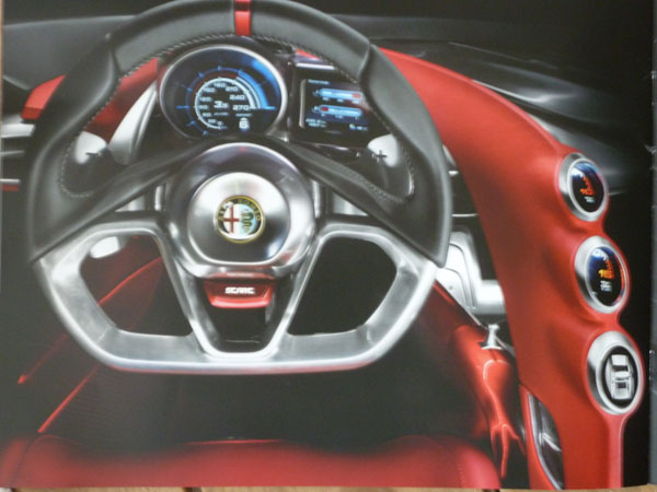 Received an Alfa 4C brochure through the post today. - Page 1 - General Gassing - PistonHeads - The image displays the interior of a luxury car, specifically focusing on the steering wheel and instrument cluster. The steering wheel is large with a metal centerpiece, featuring the Alfa Romeo logo prominently. The car appears to be well-lit, with the light blue background hinting at the open sunroof above. Speedometer and indicator lights indicate a high-end model equipped for high-speed driving. The wheel is fitted with red buttons, likely for audio controls or mode changes.