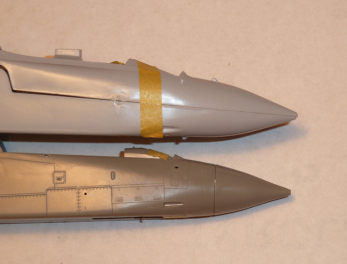 A close up of a plane with a sky background - Pistonheads - The image presents two model rockets resting side by side against a light grey background. The larger rocket exhibits a grey and gold hue, with the gold duct tape adhering to its surface. The smaller rocket showcases a silver color with transparent parts, including its nose cone. The relative position and the unique features of each model rocket make the image intriguing.