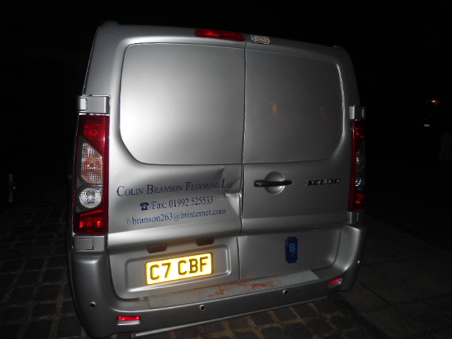 Di*khead of the week award? - Page 1 - Commercial Break - PistonHeads - The image captures the back view of a silver van parked on a dark road at night. The vehicle has a metallic finish and its license plate reads "C7 CBF". On the back bumper of the van, there is a printed logo and contact information with the text "Colin Branson Flooring Ltd.". The tail lights are illuminated, giving a slight glow against the dark backdrop.