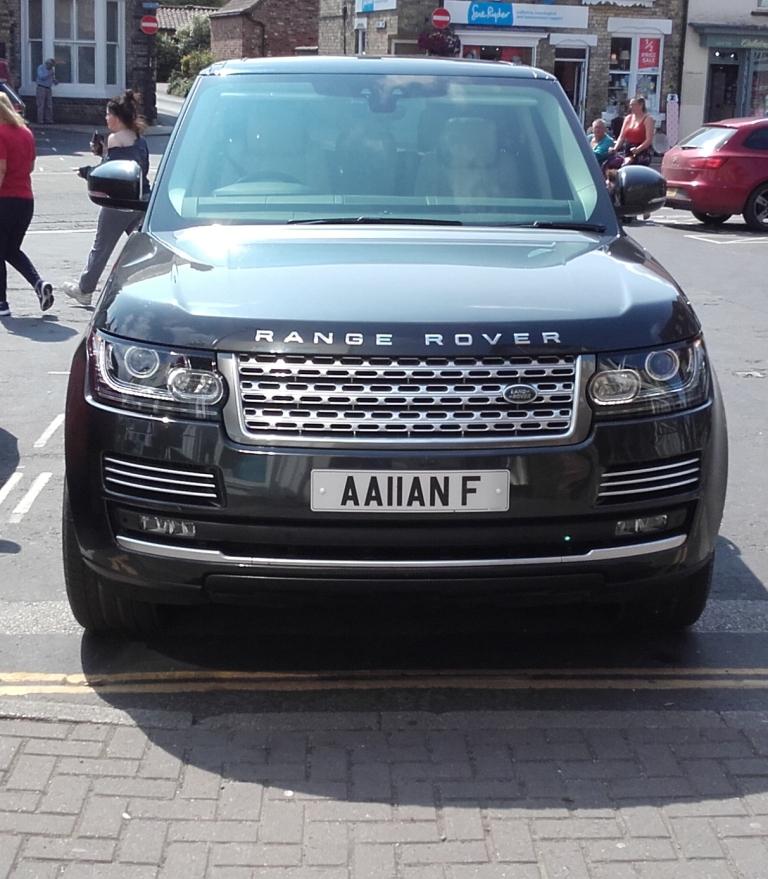 What C124PPY personalised plates have you seen recently? - Page 499 - General Gassing - PistonHeads - The image is a photograph showing a black luxury SUV parked on a street. It features the registration plate "A16 FFZ," and the model of the vehicle appears to be an Audi Range Rover, as indicated by the brand's logo in the grille. There are people walking nearby, suggesting a public area or city street. The ground is paved with concrete, and the vehicles and pedestrians create a sense of urban activity.