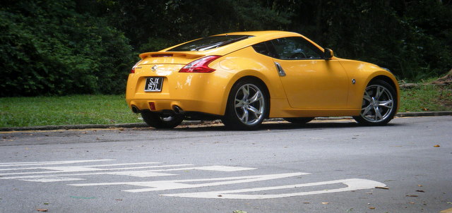 time we had pictures of everyones jap wagons - Page 56 - Jap Chat - PistonHeads - The image features a vibrant yellow Nissan ZZR sports car parked on a paved road. The car stands out with its silver rims, a visible text on the driver's side, and a distinctive three-door coupe design. The car is facing towards the left side of the image. The background includes a grassy area and trees, suggesting a suburban or rural setting. The overall scene is clear and well-lit, likely during daytime hours.