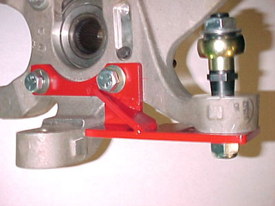 Rear Suspension Failures In Vipers - Page 1 - Vipers - PistonHeads - The image displays a scene focusing on a mechanical component, which appears to be part of an engine. Prominently, a red bracket with a pair of fasteners is positioned at an angle to secure the component into place. Above the bracket, there is a metallic attachment that could be part of a larger system. To the top right, there's a cylindrical part that stands vertically with a shiny finish, surrounded by other unidentified metal parts. The image is close-up, allowing for clear visibility of the texture and details of the metallic components. The background is a plain white surface, which is typical in a garage or workshop setting.