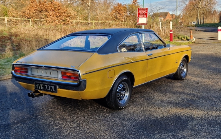 Pistonheads - The image shows a vintage car parked on what appears to be an asphalt surface. The vehicle has a classic design with yellow bodywork and black trim, including the roof. It features a small, round rear window and a white license plate. The setting suggests it might be in a rural or semi-rural area due to the open space and the presence of some trees in the background. There is no text visible in the image.