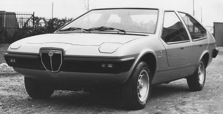 Panther Ferrari Pistonheads - The image is a black and white photograph depicting an old car, likely from the 1980s judging by its design and the style of the photograph. The car is facing the camera, parked on a gravel-covered surface. It has a hatchback design with a rear window. The vehicle is equipped with two roof racks, and as you approach the front, there's a small, distinctive badge on the grille. The photograph's composition and subject matter suggest it was taken for a purpose related to automotive history or documentation.