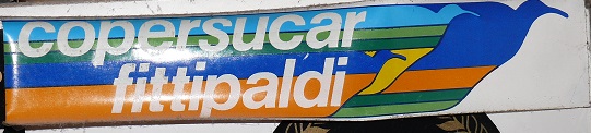 Show Us Your Stickers! - Page 1 - Formula 1 - PistonHeads - The image features a sign that prominently displays the word "copersucar." The sign also includes text in Italian and French, indicating that the context is multilingual. It appears that the sign is attached to a pole, and there is a faint floral pattern at the bottom of the sign. The colors used on the sign are vibrant, with a mix of blue, orange, and green hues.