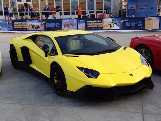 Pistonheads - In the image, a vibrant yellow Lamborghini Gallardo is the centerpiece, parked on a concrete surface. The car is sporty and sleek, with a curved design and large, black wheels that contrast with its bright yellow body. The sun is shining, casting a warm glow over the car's surface and highlighting its polished exterior. In the background, you can see a crowd of people observing the car, suggesting that this might be a special event, perhaps an auto show or a car show. The majority of the crowd is visible, with several individuals standing at a safe distance, taking in the sight of the yellow sports car.