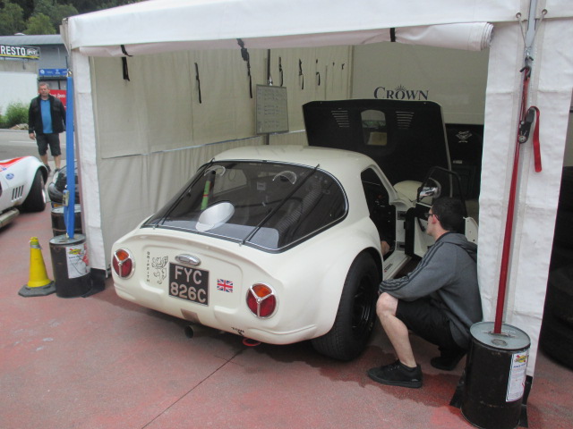 Spa 6 hours, 2015 - Page 1 - Classics - PistonHeads - This image captures a scene at a car show where a man is peering inside a white classic, possibly a Ford, given the visible brand emblem on its side. The car is stationed inside an indoor tent, suggesting that it is part of an exhibition or sale. Antique cars are often restored to their original condition, and this particular car has been painted white with striking red tail lights, hinting at meticulous preservation or restoration. In the background, a variety of other cars can be seen under the tent, creating a vibrant, bustling atmosphere typical of a car show. The man, possibly an owner or enthusiast, is dressed casually, indicating that this event is open to the public.