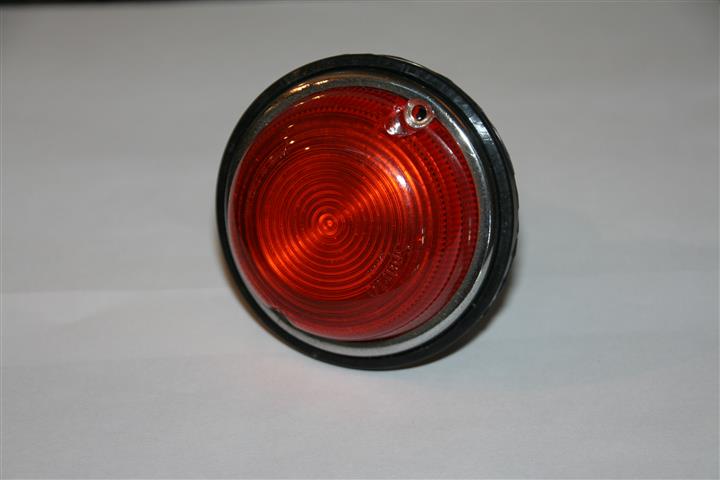 A red and white blender sitting on top of a table - Pistonheads - The image features a single, round, red tail light. It is likely a part of a vehicle or possibly a model for such vehicles. The light casts a minor reflection onto the solid blue background, suggesting a slightly textured surface beneath it. Its base is narrow and black, some silver elements can be seen around it. The overall style of the image is straightforward, focusing on the light as the primary subject.