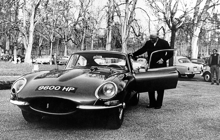 Pistonheads - The image is a black and white photograph, capturing a moment in time featuring a vintage car. The car, with its round headlights and distinctive body shape, is the focal point of the image. A man stands next to it, seemingly inspecting or admiring the vehicle. In the background, there are trees that provide a natural backdrop to this scene. The photograph has a nostalgic quality, suggesting it might be an old photo.