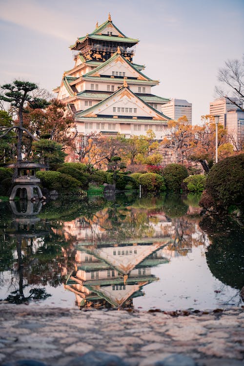 Free Green and White Castle Building Near Body of Water Stock Photo