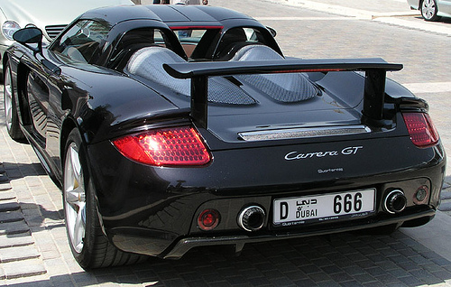 Dubai number plates - Page 1 - Middle East - PistonHeads - The image features a black sports car parked on the side of a road. The car's design, characterized by a wide body with prominent wheel arches and a large rear spoiler, suggests it belongs to a high-performance category, possibly a supercar. On the back of the car, the text "F-ST", "GT", and a license plate that reads "DO 66" is visible. The license plate number appears to be both novel and likely also significant symbolically, indicating that the car may belong to someone who enjoys a certain level of notoriety. The rear of the car is clearly highlighted by its red taillights and the number of the plate. The car is positioned on a cobblestone street, adding a touch of urban realism to the image.