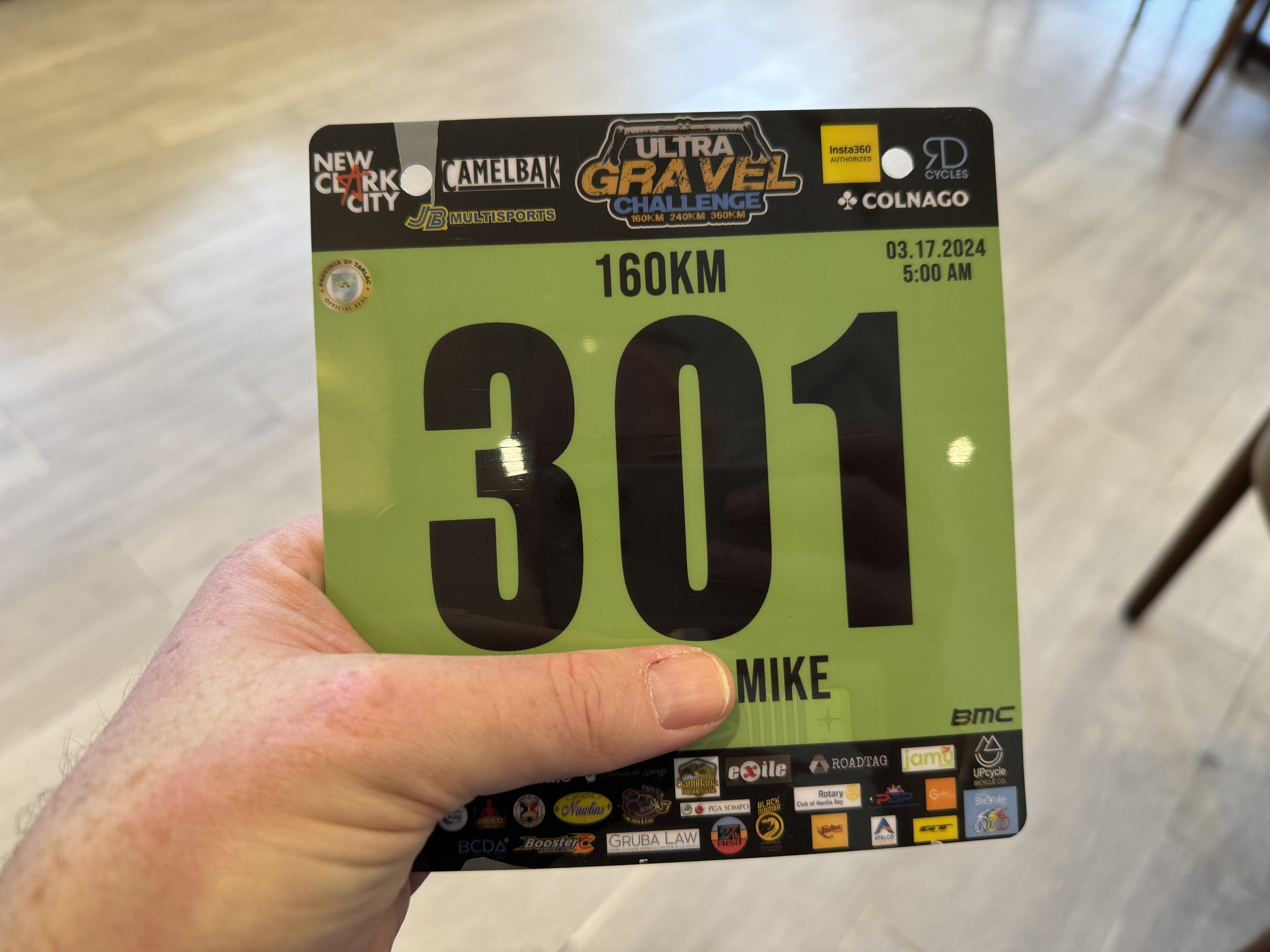 Pistonheads - The image features a person holding up a race number tag. The number is 301, and the individual has a microchip attached to it for tracking purposes. This suggests that the person may be participating in a running event or competition. In addition, there are various logos and sponsor names on the number tag, indicating that this event is likely supported by multiple organizations. The background appears to be an indoor setting with a white surface, possibly a wall or floor of a building hosting the race.