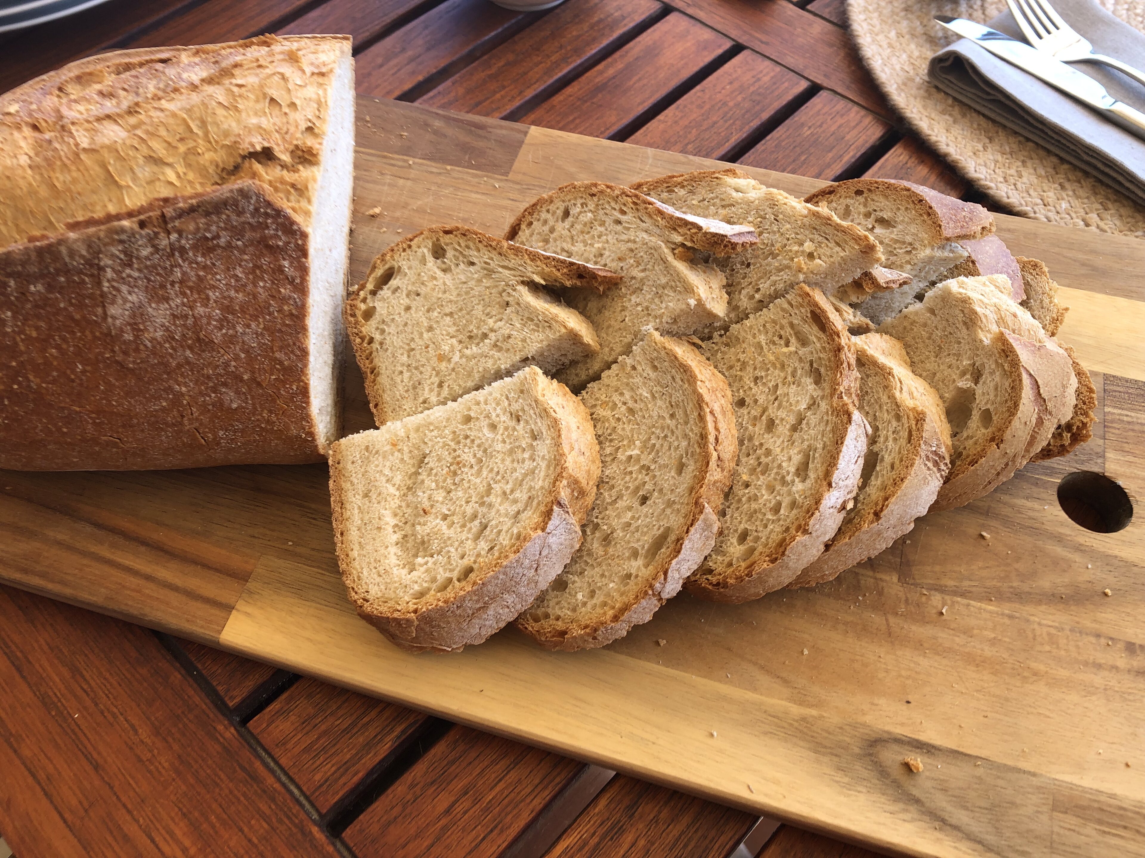 Pistonheads - The image features a rustic dining table set with slices of bread and a loaf. The bread is on a wooden cutting board, and the loaf is behind it, resting on a white plate. The table setting suggests that someone might be preparing to enjoy a meal or snack consisting of bread. The background appears to be a kitchen or dining area with warm lighting and a cozy ambiance.