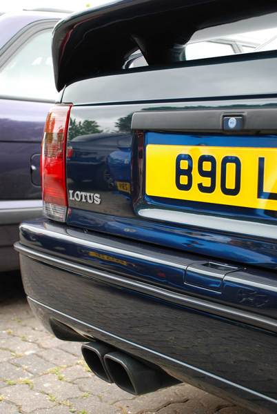 RE: PistonHeads Sunday Service: 25/07/10 - Page 9 - Events/Meetings/Travel - PistonHeads - The image features the rear end of a black Lotus car, parked in front of another car. The Lotus car is a clear 890L model, as indicated by the license plate and the "Lotus" logo just below the taillight. The car stands out against the backdrop of the driveway or parking lot with its sleek design and white smoke stack. The license plate reads "890L". The car's design and condition suggest it is well-maintained and cruises the streets with style.