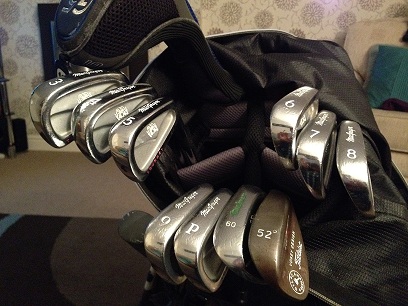 Pistonheads - The image showcases a golf bag filled with a variety of golf clubs. The clubs are made of stainless steel and have gray, silver, and black designs. Some clubs also feature personalized writing on them. The bag, which is black, is set against a lighter-colored background, making the golf clubs stand out. The overall scene gives off a sporty and polished vibe, typical of golf equipment.