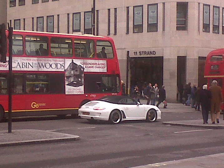 A red double decker bus driving down a street - Pistonheads