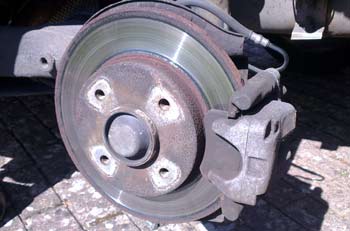 A close up of a fire hydrant on a city street - Pistonheads - The image showcases a close-up view of a dirty car brake drum. The drum is firmly attached to the vehicle. There are three bolts visible on the brake drum, with the central bolt being slightly more prominent. The drum has metal spokes that are connected in the center, and they appear to be slightly worn from use. There's also a shadow on the right side, suggesting the angle at which the photo was taken.