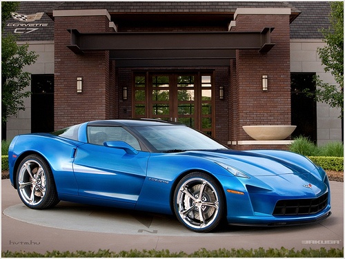 Latest render of a C7 Corvette   - Page 1 - Corvettes - PistonHeads - The image presents a sleek, blue, two-door Corvette convertible, parked in front of an imposing brick house. This vehicle is positioned on a circular driveway, and each of its four tires has a unique silver rim. In the backdrop, there's a tidy lawn punctuated by a large tree, providing a contrasting natural element to the architectural setting. The car is in sharp focus, emphasizing its design and color, while the background is slightly out of focus, drawing attention to the car.