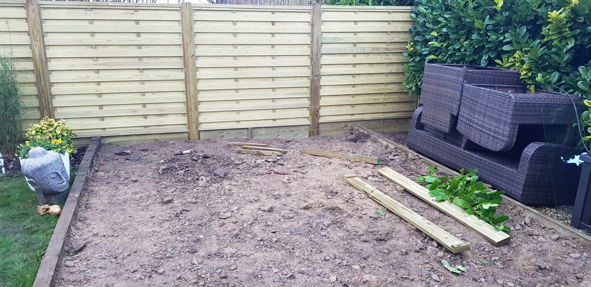 Fixing all our (first world) 'issues' with the Garden - Page 1 - Homes, Gardens and DIY - PistonHeads - The image shows a backyard area in the middle of construction. A wooden fence is being built behind what appears to be a garden bed with bare soil. A path made of pavers leads into the space, and the ground is mostly uncovered, revealing the raw earth. There are no visible plants or landscaping features yet. In the foreground, there's a section of grass on the left side, suggesting that the yard isn't entirely being worked on at this time. The fence, garden bed, and pathway are in the process of being installed.