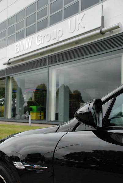 RE: PistonHeads Sunday Service: 25/07/10 - Page 9 - Events/Meetings/Travel - PistonHeads - The image shows the front end of a car parked in front of a building with a sign that reads "BWM Group UK". The car appears to be a luxury model, possibly a sports car, with a sleek design and a polished finish. The building seems to be an office or corporate facility, likely associated with the BMW Group. The setting looks like a typical business environment.