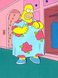 Broaching the subject of her weight gain - Page 8 - The Lounge - PistonHeads - The image portrays Homer Simpson, a beloved character from the animated television show "The Simpsons". He is standing in a pink room, dressed in a vibrant blue robe adorned with pink and green floral patterns. In his hands, he holds opening scissors, suggesting he's about to cut something. His pose, with one hand confidently on his hip and the other holding the scissors, exudes a sense of excitement or anticipation. The overall scene is a snapshot of a ordinary yet humorous moment in the life of Homer Simpson.