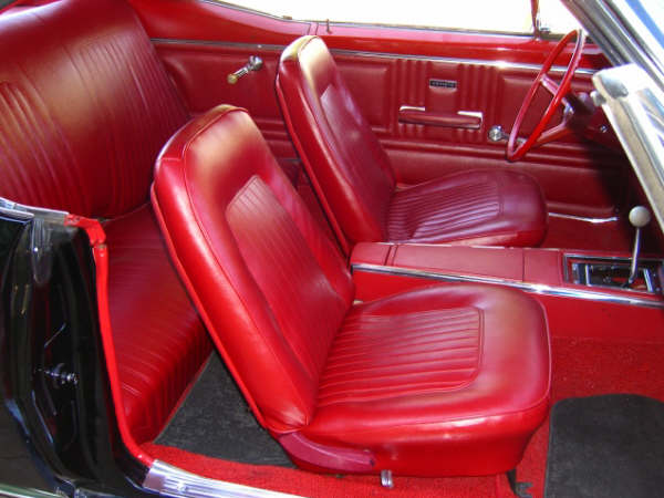 Worth Pistonheads Camaro - The image showcases the interior of a classic car, predominantly finished in vibrant red. The central focus is the back passenger seat, visible in its full expanse with red leather upholstery. The backrest of the seat has a diamond pattern, adding to the classic design. On this seat, there's a headrest for both driver and passenger, suggesting that this is a passenger-side seat. The car's interior, including the seat, has been meticulously cared for, as evidenced by the immaculate red leather, which is pristine and devoid of any visible wear or tear.