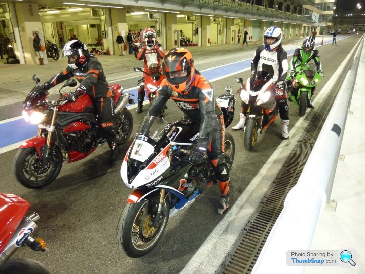 A group of people riding motorcycles down a street - Pistonheads - The image showcases a vibrant scene on a racetrack. A group of motorcyclists, each wearing colorful suits and helmets, are neatly lined up on their motorcycles. They are positioned in such a way that they are facing away from the camera, presenting their backs as we view the scene. A red motorcycle at the front of the line seemingly pulls the others along, creating an impression of a formation race.

The racetrack itself is neatly paved with a clear strip indicating the racing lanes. The surrounding environment is a blur, emphasizing the motion and focus of the racers. Despite the colorful attire of the riders, it's evident that safety is taken seriously, as indicated by the helmets they wear. The ambiance suggests an exciting motor racing event in progress.