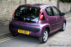 Best 2 Car Combos - Page 3 - General Gassing - PistonHeads - The image showcases a vibrant purple-colored smart car parked on the side of a street, facing the left side of the photo. The car's license plate is clearly visible, reading "KY12 SRA". There is a watermark in the corner that reads "ROBERSON CARS". The car appears to be in good condition, with standard alloy wheels. In the background, there's a stone wall on the right side of the photo, providing a contrast to the modern vehicle.