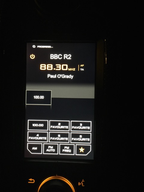 12C IRIS 2 - DAB? - Page 1 - McLaren - PistonHeads - The image shows a digital display screen on a device, presumably an electronic gadget or control panel. The screen displays various pieces of information, including "BBC R2," with a subsection indicating a channel number "88.30," an "AF" or Frequency marker, and "TA," likely meaning "Time Availability" or "Transmission Audio." Additionally, there are labels for "FAVOURITE," "RECEIVER," with corresponding star symbols, "FM," "AM," and "FM FREQ," suggesting the device's multimedia radio features. The screen also indicates a "$99.00" cost, indicating an associated price or value. The text at the bottom is clearly lit up, indicating the device's power or the status of the screen, which is in an "in progress" or on status.