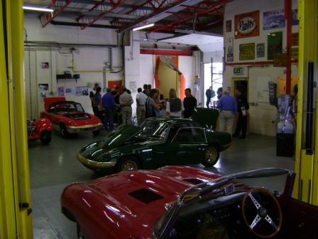 Pictures from Paul Roach's Open Day - Page 1 - Classic Cars and Yesterday's Heroes - PistonHeads - The image shows a spacious room with high ceilings. Inside the room, there are several sports cars on display. The cars are various models and colors, including red, white, and black. Some people are present in the room, standing around and observing the cars. A wall clock is visible in the background, providing context to the scene. The overall impression is that of a car show or exhibit in a warehouse-like setting.