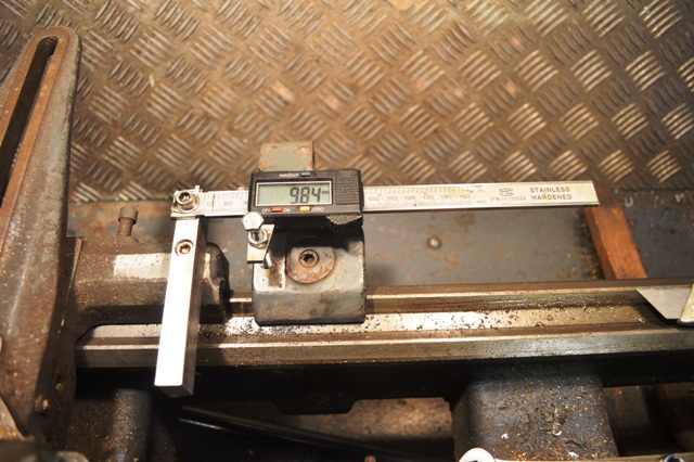 A black and white photo of an old stove - Pistonheads - The image features a mechanical device with a dial gauge, a tool used for measuring linear distances. The dial gauge is mounted on a flat surface with a textured pattern, possibly a table or a bench. There's an L-shaped bracket attached to the top of a metal beam that lies horizontally across the image. Above the dial gauge, there's a combination of numbers and letters strung along a straight line. The focus of the image is the precision measurement tool, the dial gauge, which is prominently displayed with its needle pointing at a reading of approximately 94 mm. The overall scene suggests a technical setting, likely part of a workshop or factory, where such measurement tools are frequently used.